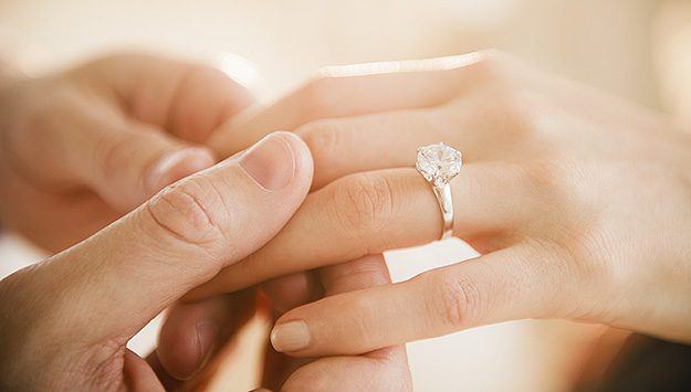 USA, New Jersey, Jersey City, Close up of man's and woman's hands with engagement ring